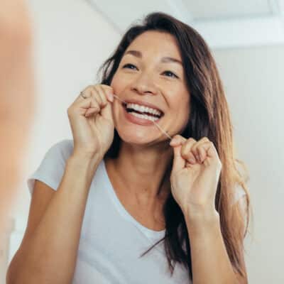 Cavities: the most important thing you need to know 3 Woman flossing her teeth