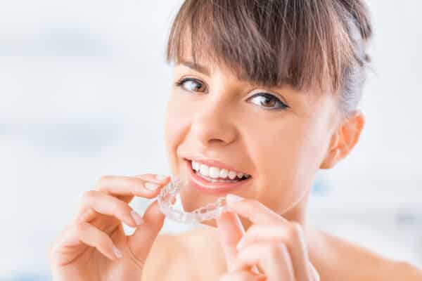 Invisalign clear aligners for adults 11 Brunette with bangs inserting invisalign