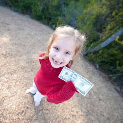 What is a baby tooth worth? 6 Little girl with missing baby teeth holding a five dollar bill