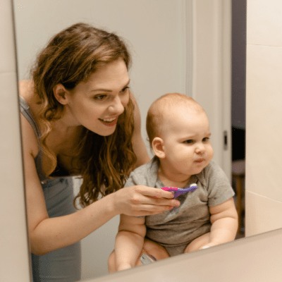 Infant child dental care 3 Young mom brushing baby's teeth