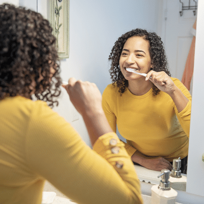Prenatal dental care 4 Young pregnant mom brushing teeth in mirror