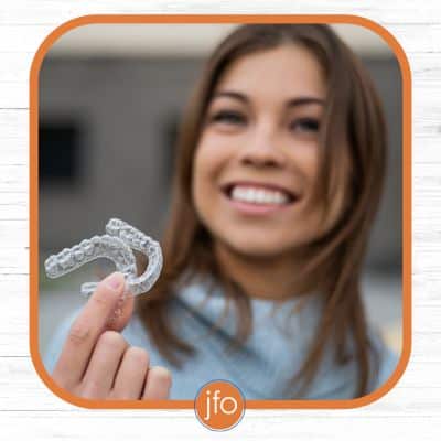 woman holding invisible aligners