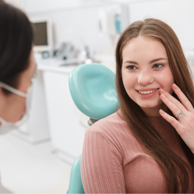 What to expect at your orthodontic consultation 5 Teenage girl talking to the dentist for orthodontic cconsultation