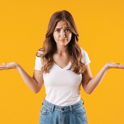 How much do braces vs aligners cost? A breakdown 6 Young woman with her hands up, deciding, representing braces vs aligners cost