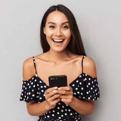 The benefits of orthodontic virtual monitoring at joosse family orthodontics 2 A woman holding a phone, smiling and excited, representing orthodontic virtual monitoring