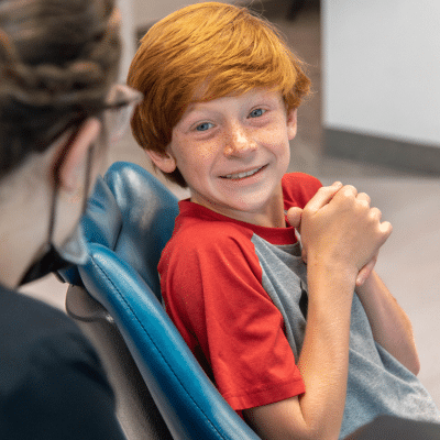 What to expect after getting braces: a parent’s survival guide 2 Little boy looking excited with hands clasped together at joosse family orthodontics, representing what to expect after getting braces